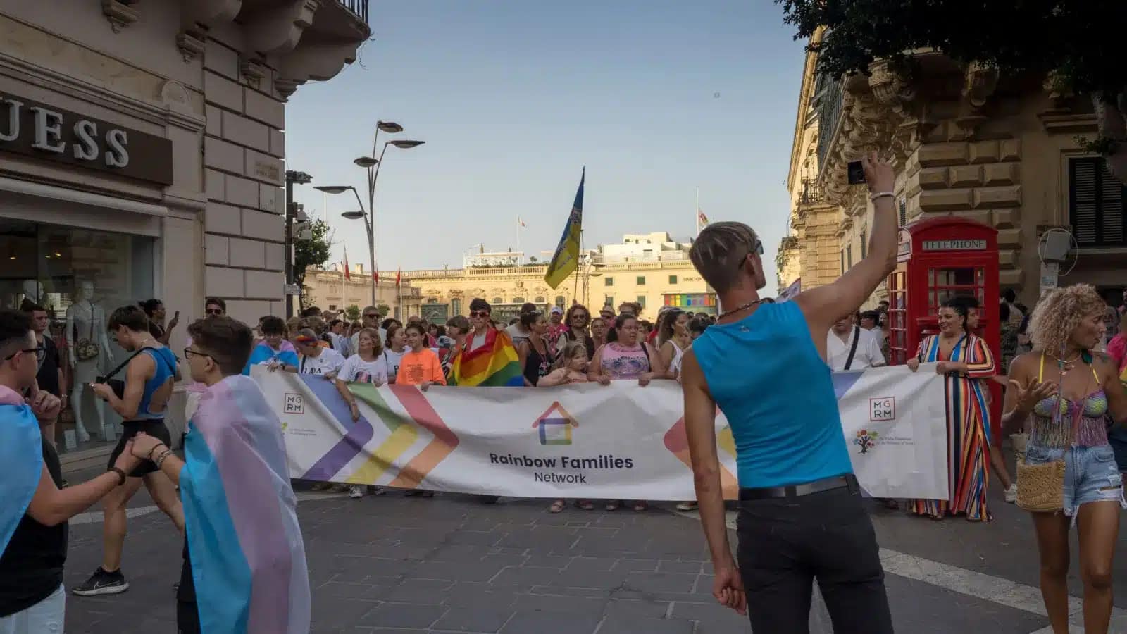 Marchers carrying a Rainbow Families Network banner through a street in Malta