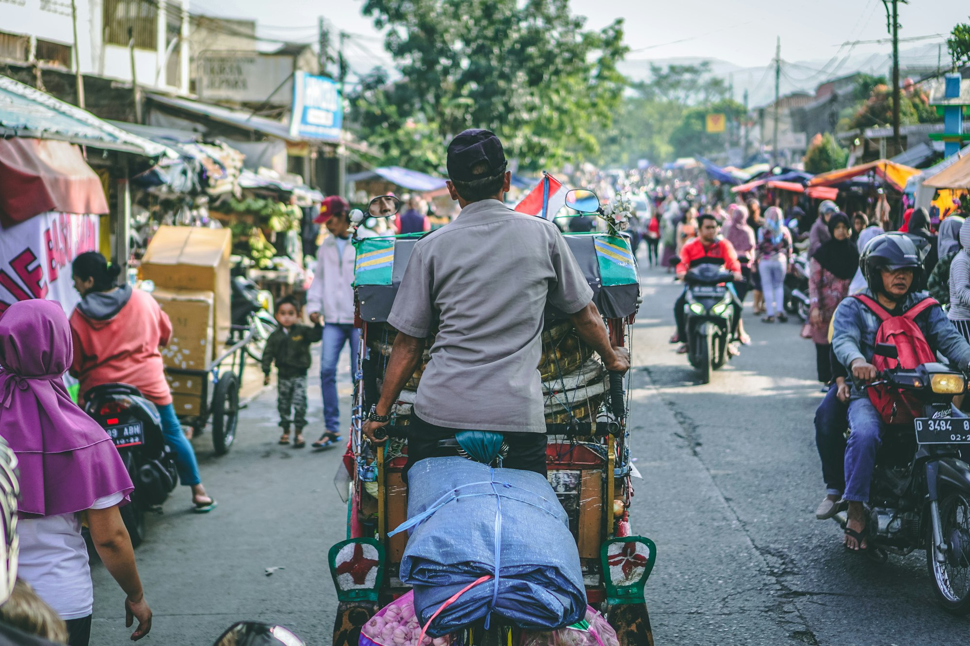 Shoppers and motorbikes crowding a street market in Indonesia