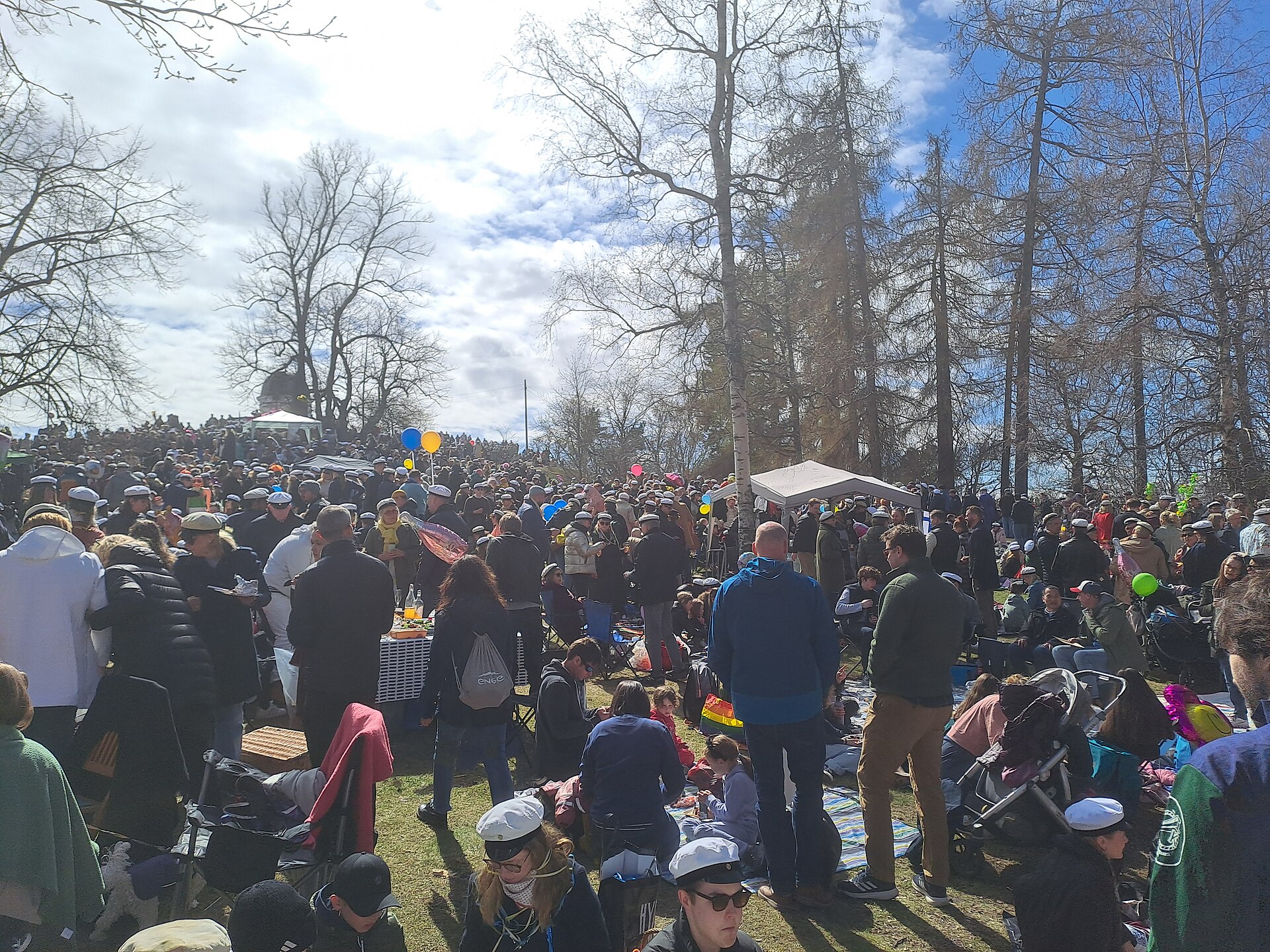 People sitting together on the grass at a Vappu picnic in Helsinki on May Day