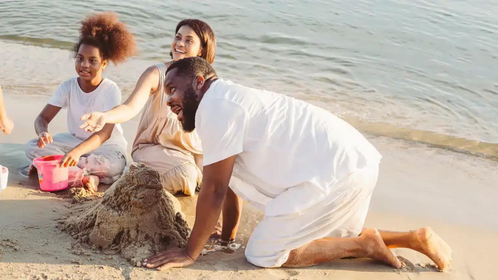 A family building a sandcastle on a Caribbean beach